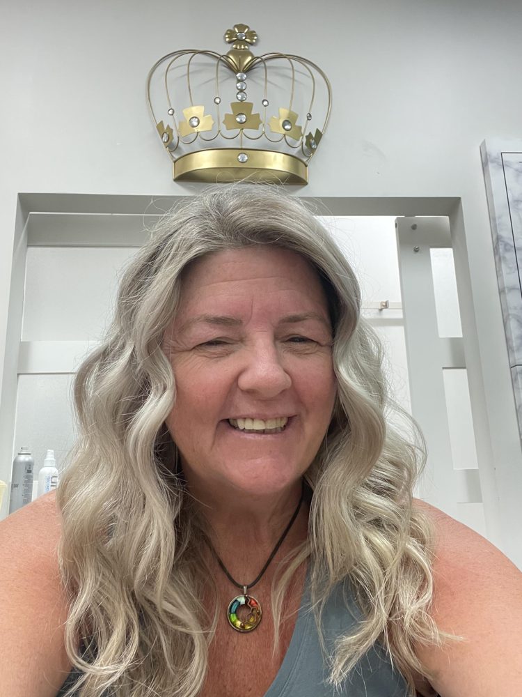 Tish with a gold crown and pendant necklace